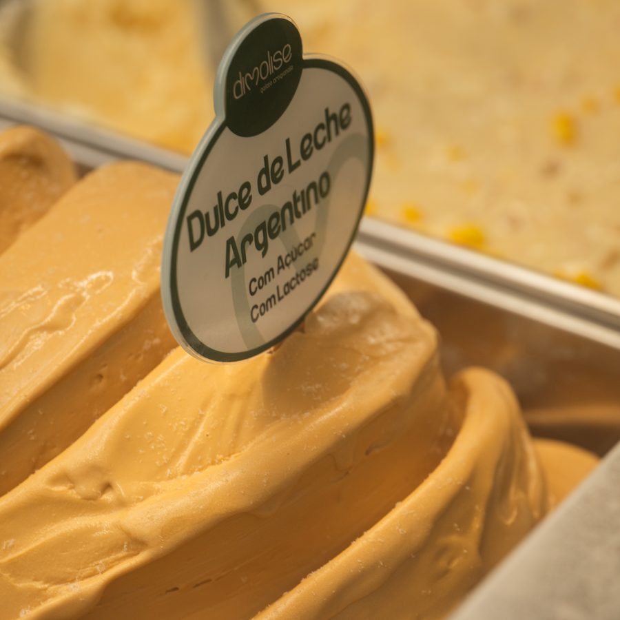 Cuba de gelato Dulce de Leche Argentino na vitrine da Dimolise, com a placa do sabor