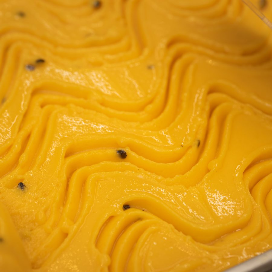 Gelato de maracujá Dimolise, amarelo intenso com sementes à mostra
